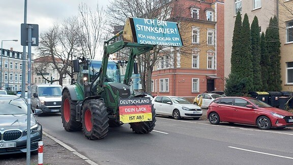 Ein Traktor mit einem Protestbanner fährt am Donnerstag durch Erfurt. Hier an der Kreuzung Schillerstraße / Pförtchenstraße