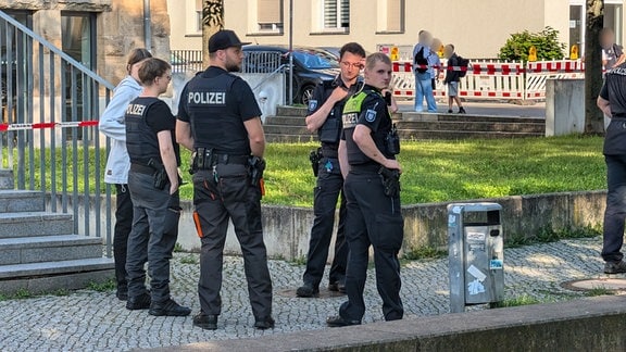 Polizeieinsatzkräfte stehen vor einer Schule.