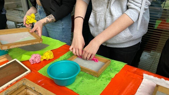 Junge Frauen schöpfen Papier im "Grünen Klassenzimmer" im Egapark Papier