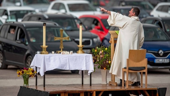 Pfarrer Christoph Knoll von der Erfurter Thomasgemeinde steht neben einem improvisierten Altar auf dem Messe-Parkplatz in Erfurt.