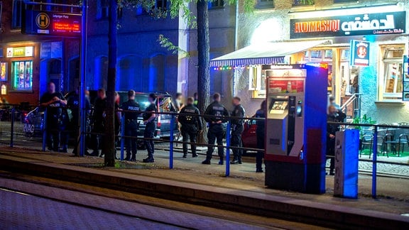 Polizei und Fahrzeuge vor einem orientalischen Imbiss am Leipziger Platz in Erfurt in der Nacht.