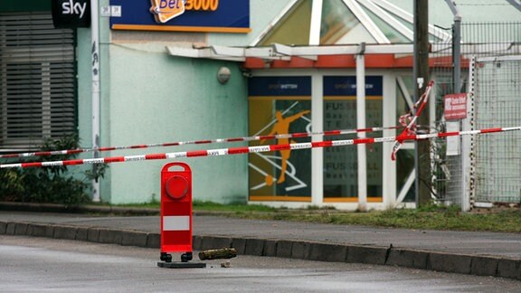 Vor einer Gaststätte in Erfurt ist rotes Absperrband der Polizei aufgespannt.