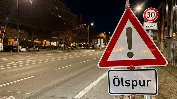Ein Warnschild vor Ölspuren steht an einer Straße in Erfurt