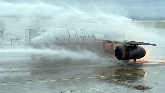 Eine brennende Flugzeugatrappe wird mit Wasser besprüht.