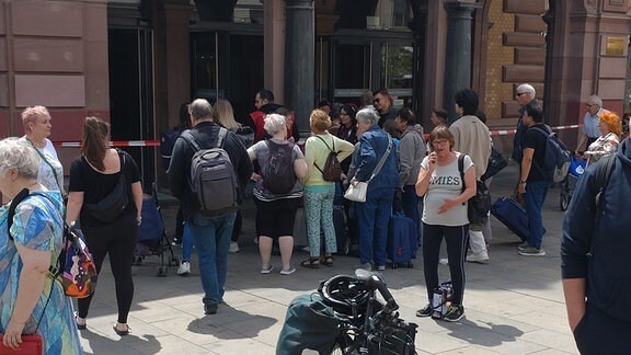 Menschen stehen vor einem Flatterband am Erfurter Hauptbahnhof