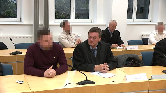 Angeklagte und Anwälte im Gerichtssaal