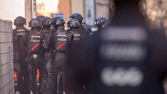 Mehrere Polizisten mit Helmen stehen nebeneinander.