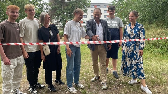 Eine Gruppe von Menschen zerschneidet ein Band.