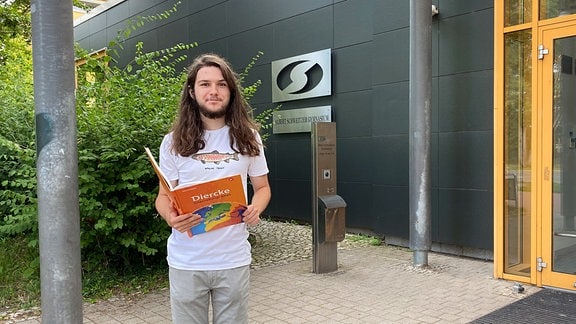 Julius Plehn mit einem Kinderbuch in der Hand