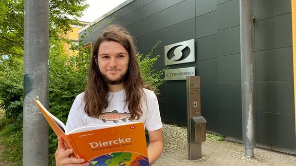 Julius Plehn mit einem Kinderbuch in der Hand