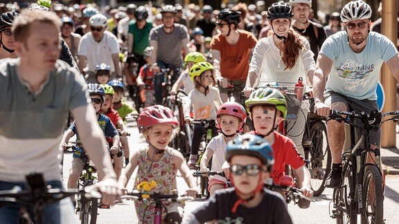 Eltern demonstrieren mit ihren Kindern auf einer "Kidical Mass" Fahrraddemo für sichere Schulradwege für Hamburgs Kinder.