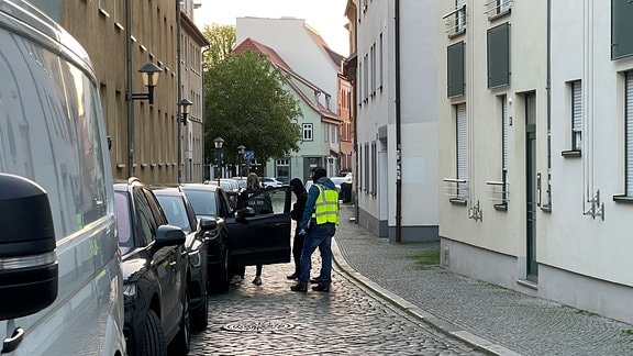 Polizeibeamte stehen an einem Auto in der Erfurter Innenstadt