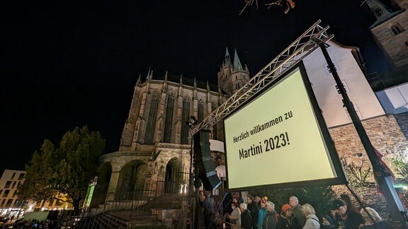 Eine große Leinwand vor dem Erfurter Dom auf der steht "Willkommen zum Martini 2023"