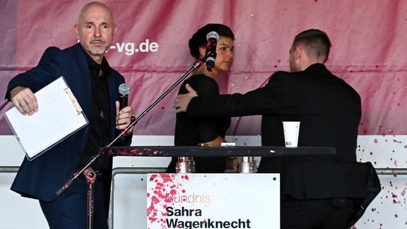 Sahra Wagenknecht, Vorsitzende des Bündnis Sahra Wagenknecht (BSW), wird von einem Personenschützer von der Bühne gebracht, nachdem es einen Angriff mit roter Farbe während der Wahlkampf-Veranstaltung auf dem Domplatz gab. Daneben steht Steffen Quasebarth, Listenkandidat des BSW. Am 1. September 2024 wird in Thüringen ein neuer Landtag gewählt.