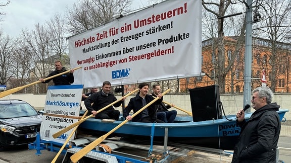 Mehrere Personen bei einer Protestaktion mit einem Ruderboot.