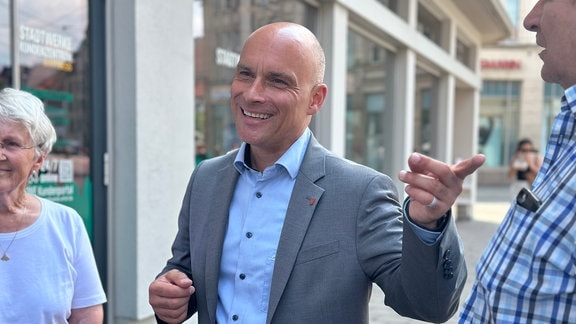 Andreas Horn, Oberbürgermeister von Erfurt, zeigt lächelnd auf etwas.