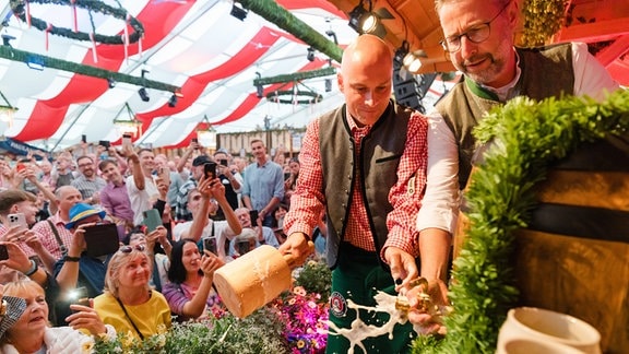 Andreas Horn (CDU), Oberbürgermeister, schlägt beim offiziellen Festbieranstich zum Erfurter Oktoberfest 2024 auf dem Domplatz den Zapfhahn in das Fass. 