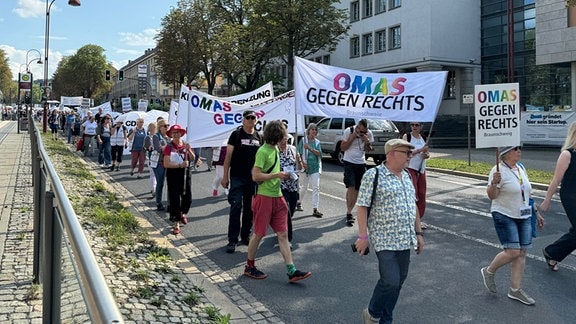 Mehrere Menschen mit Transparenten und Plakaten auf einer Demonstration der "Omas gegen Rechts" in Erfurt.