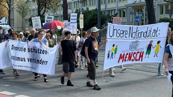 Mehrere Menschen mit Transparenten und Plakaten auf einer Demonstration der "Omas gegen Rechts" in Erfurt.