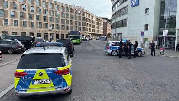 Polizeiautos, ein Flixbus und Polizeibeamte stehen auf einer Straße in Erfurt.