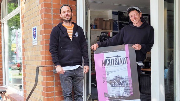 Tom und Kubi halten ein Plakat des Films "Nichtstadt"