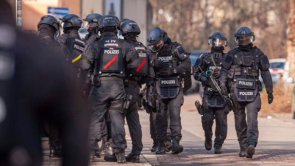 Polizisten begleiten Kinder aus einem Schulgebäude