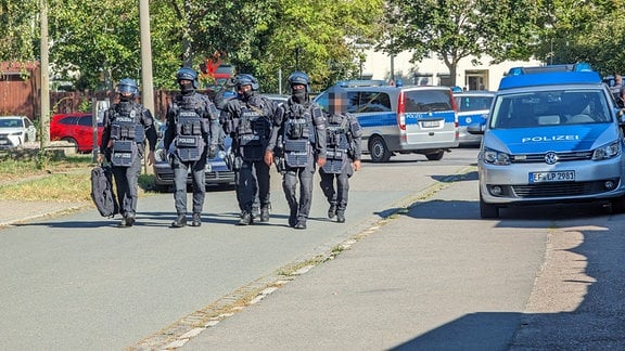 Eine Gruppe von Polizisten läuft auf einer Straße.