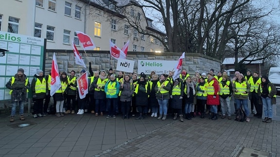 Beschäftigte des Helios-Klinikums Erfurt streiken mit Transparenten, Verdi-Fahnen und Warnwesten
