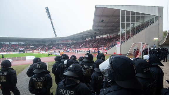 Polizeieinsatzkräfte stehen in einem Stadion.