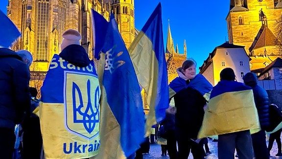 Menschen demonstrieren mit Ukraineflaggen vor Erfurter Dom