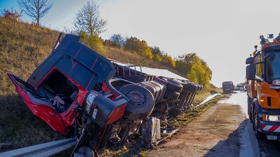 Ein Lkw liegt im Seitenstreifen.