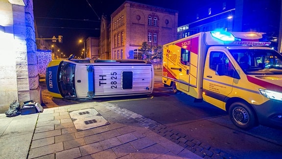 Nach einem Unfall liegt ein Polizeitransporter umgekippt auf der Straße.