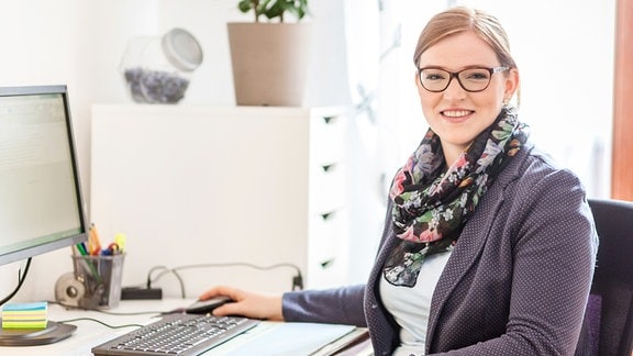 Frau sitzt an einem Schreibtisch