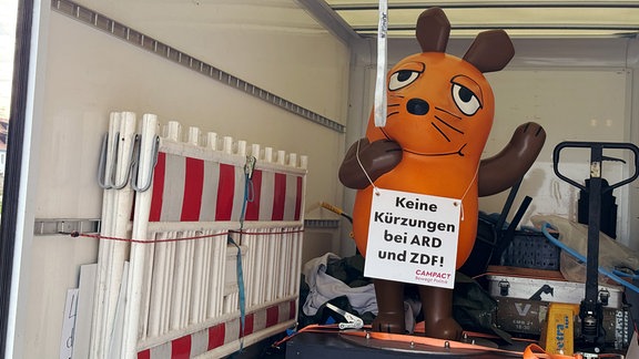 Eine Figur der Maus in der Ladefläche eines Lkw.