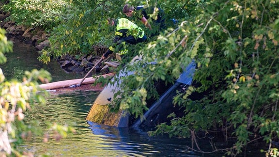 Feuerwehrleute bergen ein Auto aus einem Fluss