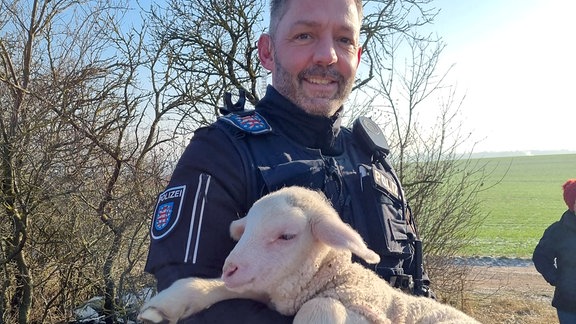 Polizist hält Schaf