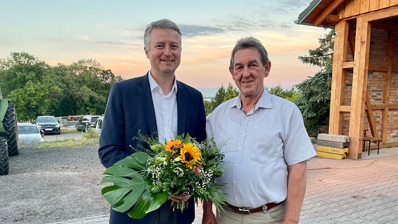 Christian Karl (CDU, links) mit einem Blumenstrauß. Rechts der scheidende Landrat Harald Henning (CDU)