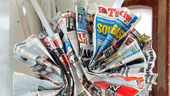 Ein Kunstwerk, das wie kreisrund zusammengeknüllte Zeitungen aussieht.