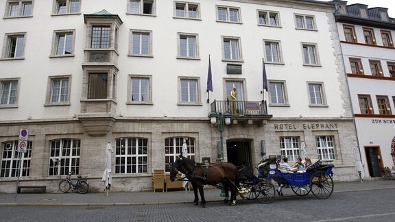 Eine Pferdekutsche vor dem Hotel Elephant am Marktplatz in Weimar