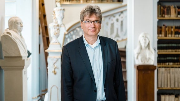 Dr. Reinhard Laube, Direktor der Herzogin Anna Amalia Bibliothek, vor Buchregalen des bekannten Rokokosaals