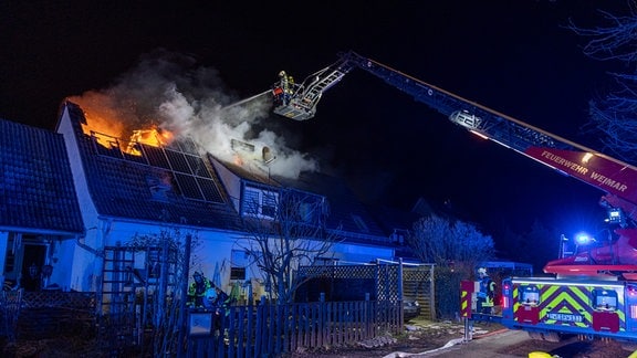 Feuerwehr löscht Wohnhausbrand.