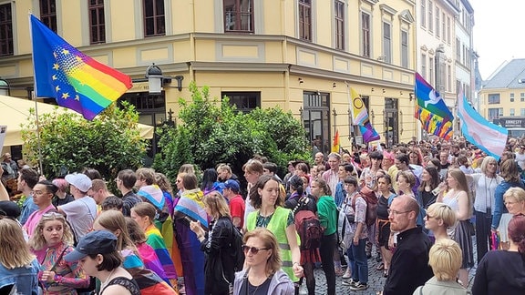 CSD Weimar 2024: Menschen ziehen mit bunten Flaggen durch die Weimarer Innenstadt