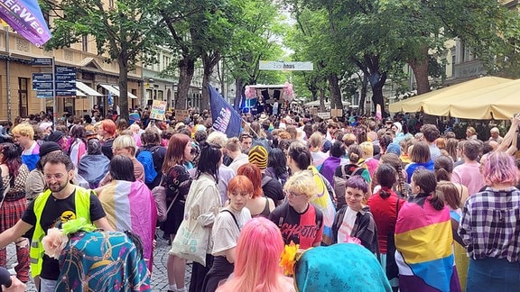 CSD Weimar 2024: Eine Gruppe von Demonstranten folgt einem Wagen durch die Innenstadt.