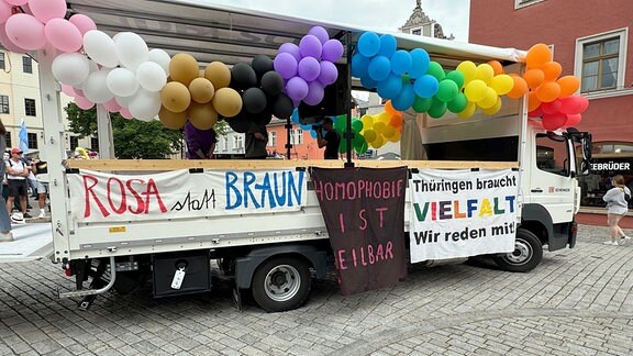 CSD Weimar 2024: Ein Lkw mit Transparenten behängt. Auf ihnen steht "Rosa statt Braun", "Homophobie ist heilbar" und "Thüringen braucht Vielfalt".