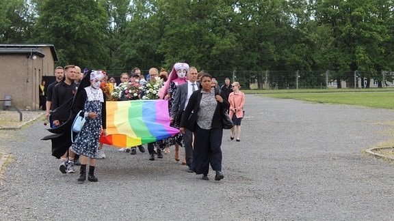 Ein Trauerzug hält eine LGBTQI-Flagge in der Hand