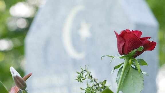Eine Rose vor einem Grabstein mit Stern und Halbmond.