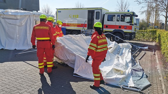 Menschen in roter Uniform bei Einsätzen des Katastrohenschutzes