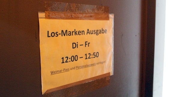 Tafel Weimar: Papierschild an einer dunklen Tür: "Los-Marken Ausgabe"