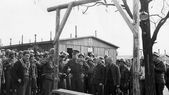 Ignaz Feldmann zeigt dem Oberbefehlshaber der alliierten Streitkräfte in Europa den Galgen im ehemaligen Außenlager Ohrdruf, 12. April 1945