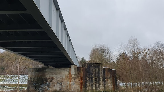 Neu gebaute Zugbrücke von unten inmitten kahler Winterlandschaft
